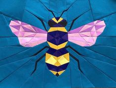 a paper piece with a bee on it's back and yellow, purple, and black stripes