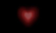 a red heart shaped object in the dark