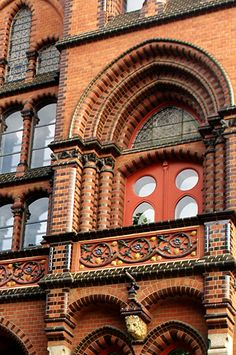 an old brick building with arched windows and a clock on the front door is shown