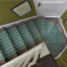 an overhead view of a stair case with green and blue striped rugs on it