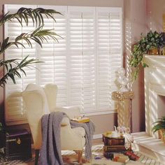 a living room filled with furniture and a fire place next to a window covered in blinds