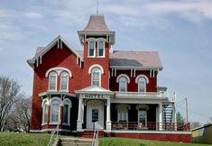 a large red brick building sitting on top of a lush green field