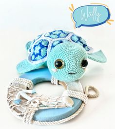 a blue stuffed turtle sitting on top of a rope