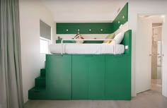 there is a bunk bed in the middle of this room with green walls and stairs