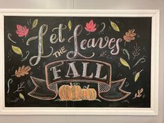 a chalk board with the words let the leaves fall written on it