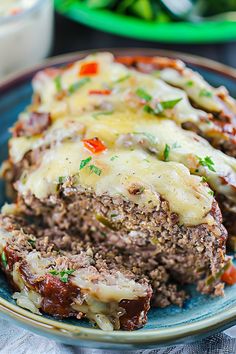 meatloaf with cheese and vegetables on a blue plate