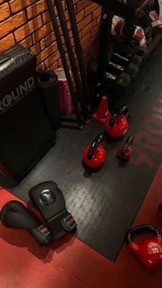 there are many pairs of boxing gloves and punching pads on the floor next to each other