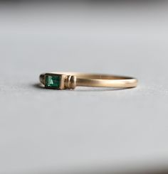 Natural emerald stone bezel ring set on solid yellow gold. Sanded finish Genuine emerald stone 3.5mm x 2mm emerald stone Stone weight: 0.090carat Cut: Baguette Band width front: 2mm Band width back: 1mm Shiny polished available upon request. All of our jewelry will arrive in custom packaging ready for gift giving. LEAD TIME: Made to order will take 10-14 days. FOLLOW US ON: Instagram: @roseandchoc Facebook: /Roseandchoc Pinterest: @Roseandchoc Stackable Emerald Ring In Yellow Gold, Stackable Yellow Gold Emerald-cut Emerald Ring, Yellow Gold Emerald-cut Emerald Stackable Rings, Gold Stackable Emerald Ring, Baguette Ring Engagement, Gold Baguette Ring, Baguette Band, Emerald Band, Natural Emerald Rings