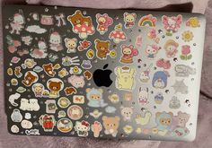 an apple laptop covered in lots of stickers