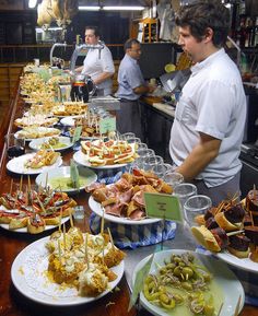 a man standing in front of a counter filled with plates and bowls full of food