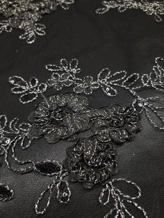 black and white lace with silver flowers on the bottom is seen in this close up photo