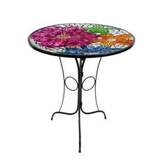 a table with flowers painted on it and wrought iron legs, against a white background