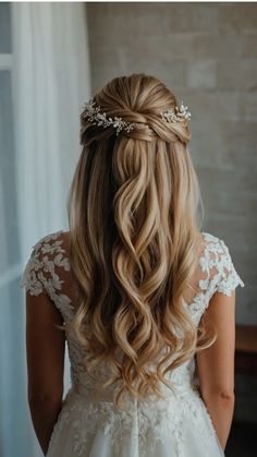 the back of a woman's head wearing a wedding dress with flowers in her hair