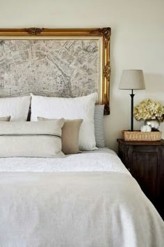 a bed with white linens and pillows in a bedroom