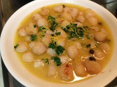 a white bowl filled with shrimp and broth