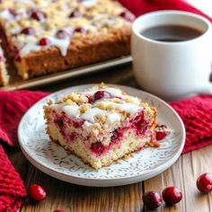 a piece of cranberry coffee cake on a plate next to a cup of coffee