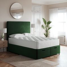 a green bed with white sheets and pillows in a room next to a mirror on the wall