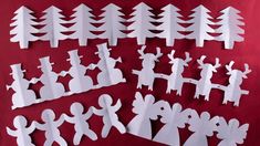 paper cut out of people and trees on a red background