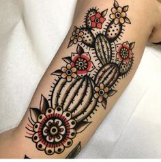 a woman's arm with a tattoo on it that has flowers and cacti