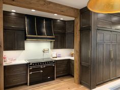 a kitchen with wooden floors and black cabinets