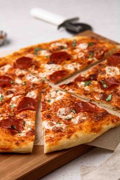 a sliced pizza sitting on top of a wooden cutting board