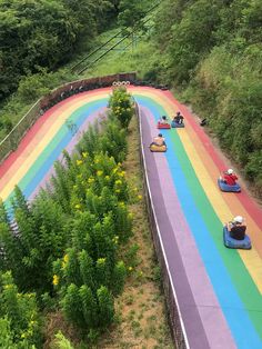 rainbow painted road with bumper cars driving down it