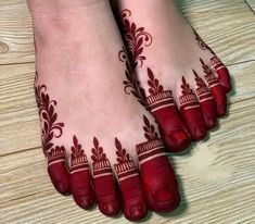 the feet are decorated with red hennap and designs on it's toes