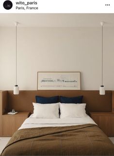 a bed with two lamps hanging above it