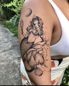 a woman with a mermaid tattoo on her arm