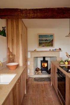 a wood burning stove in a kitchen next to a sink and counter top with wooden cabinets