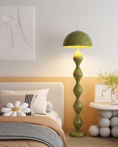 a green lamp sitting on top of a bed next to a white table