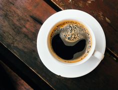 there is a cup of coffee on the table with its foamy liquid in it