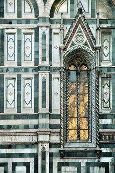 an ornate building with a clock on it's face and stained glass window above the door