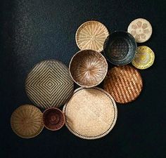 several woven baskets sitting on top of a black table next to each other with different designs