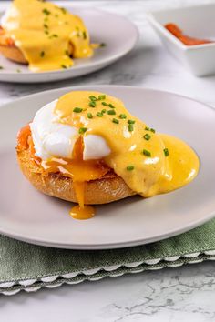 two white plates topped with eggs and cheese