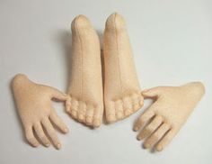 three pairs of beige knitted hands on a white surface