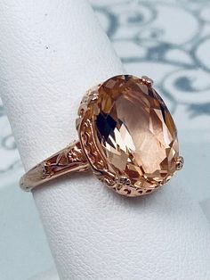 Simulated Peach Topaz Ring  Edward Design#70 Inspired by Edwardian jewelry of the early 1900s, I now offer this lovely Antique reproduction ring in sterling silver with rose gold overlay. This gorgeous ring is set with a stunning Simulated Peach Topaz gemstone. This gemstone has excellent color and clarity. The oval cut topaz is 14mm (9/16th of an inch) Long by 10mm Wide (3/8th"), (slightly smaller gemstone also available upon request). The ring sits 6mm off the finger. The inside of the band is Formal Rose Gold Topaz Ring With Accent Stones, Classic Gold Morganite Jewelry, Classic Morganite Gold Jewelry, Heirloom Rose Gold Topaz Gemstone Ring, Heirloom Morganite Rose Gold Jewelry, Heirloom Rose Gold Morganite Jewelry, Classic Rose Gold Topaz Ring, Classic Rose Gold Topaz Ring For Formal Occasions, Classic Rose Gold Topaz Ring For Formal Events