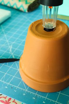 a small lamp sitting on top of a table next to a cutting board and scissors