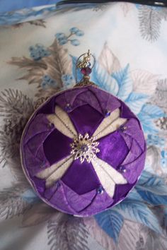 a purple ornament with white dragonflies on it