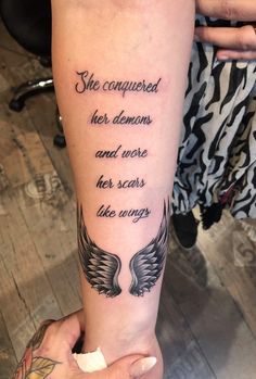 a woman with a tattoo on her arm that says she captured her demons and wrote her scars like wings