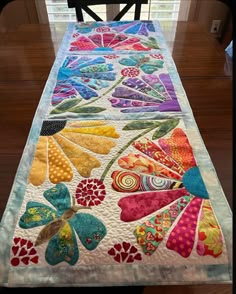 a quilted table runner with colorful flowers on it