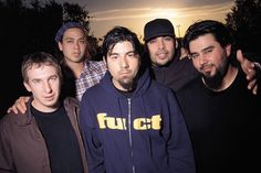 a group of young men standing next to each other in front of the sun at night