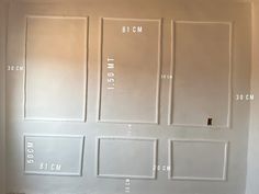 a room with white walls and measurements for the paint on the wall in front of it