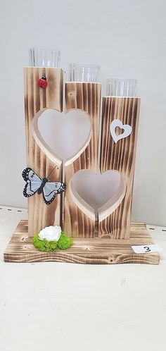 a wooden stand with two glasses and a butterfly on it