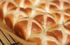 freshly baked hot cross buns sitting on a cooling rack