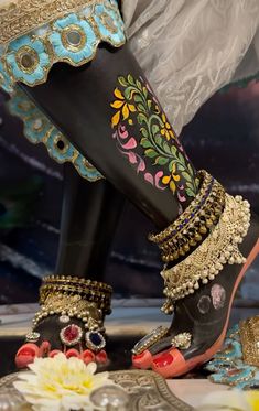 there is a woman's feet with colorful jewelry on them