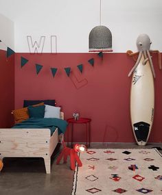 a bedroom with a surfboard on the wall and a rug in front of it