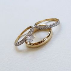 two gold wedding rings with diamonds on them