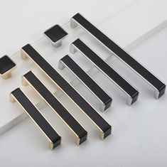 several black and gold drawer pulls on a white surface