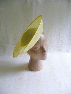 One contoured saucer with an upturned brim hat sinamay straw fascinator / hat base in yellow that measures approximately 12" (30.5 cm) in diameter. The base is contoured to fit against the head. The edges of the brim are finished in sinamay. The multi-layer stiffened sinamay straw has a great sturdy weave and provides excellent support for your millinery creations. This is NOT a ready to wear finished hat and it will not stay on your head unless you add a head band to wear. Add embellishments of your choice. ASinamay is a natural material and you may see some color striations in the weave. This is not a defect, but is the result of how different natural fibers respond to dye.  nice high quality base - I know you'll be pleased! This hat base is listed separately in fuchsia pink, white, cora Spring Adjustable Sinamay Fascinator, Spring Sinamay Fascinator, Spring Sinamay Fascinator Hat, Sinamay Fascinator Hat For Spring, Spring Church Sinamay Fascinator, Fitted Sinamay Brimmed Top Hat, Spring Fascinator With Sinamay And Curved Brim, Fitted Summer Cloche Costume Hat, Spring Church Fascinator In Sinamay